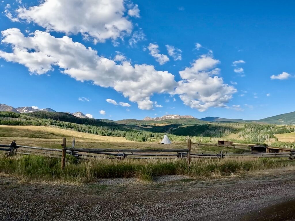 A view of a Tepee nestled in front of majestic mountain views outside of Telluride.