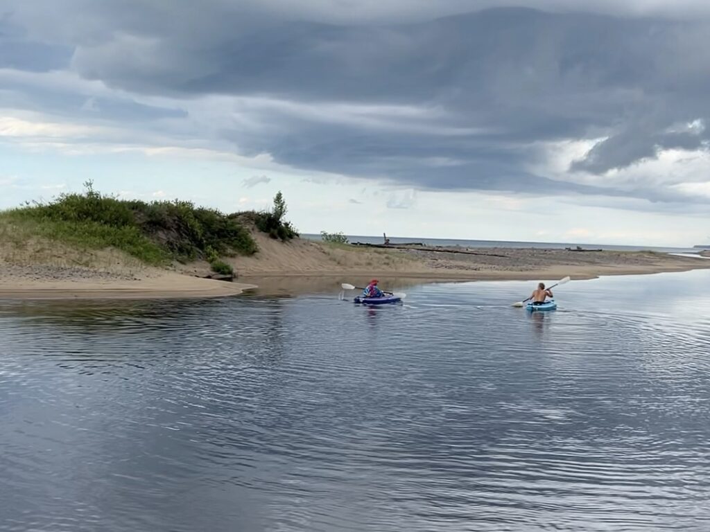 Kayakers paddling at the mouth of the Two Hearted River.